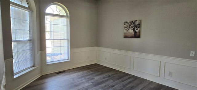 9201 N Harrison St, Kansas City, MO 64155 - spare room featuring wainscoting, dark wood finished floors, and a decorative wall