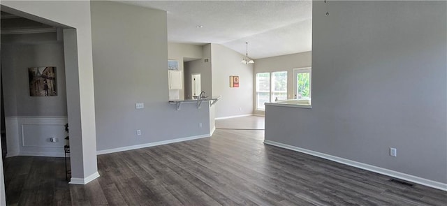 9201 N Harrison St, Kansas City, MO 64155 - unfurnished room featuring lofted ceiling, dark wood-style floors, baseboards, and a chandelier