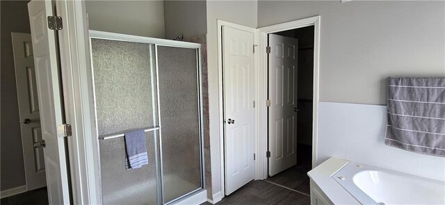 9201 N Harrison St, Kansas City, MO 64155 - bathroom with a shower stall, a bath, and wood finished floors
