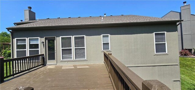 9201 N Harrison St, Kansas City, MO 64155 - back of property with a wooden deck, roof with shingles, and a chimney