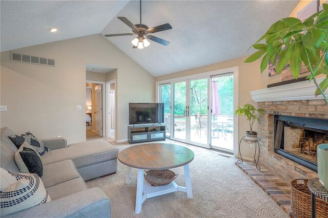 carpeted living room with ceiling fan, lofted ceiling, a textured ceiling, a fireplace, and baseboards