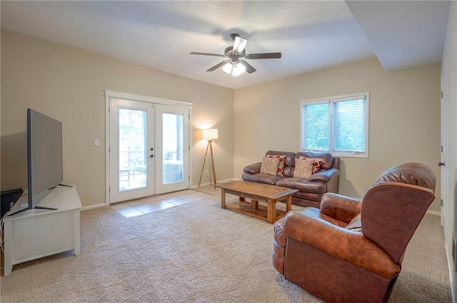 living room with french doors, plenty of natural light, carpet flooring, and a textured ceiling
