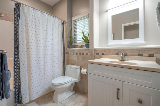 bathroom with tile walls, toilet, tile patterned floors, vanity, and a shower with shower curtain