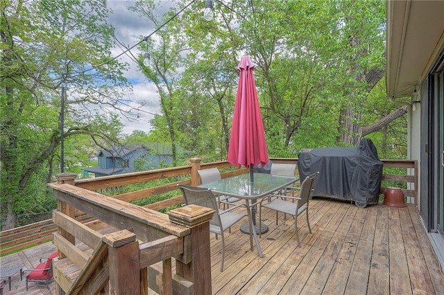 deck featuring outdoor dining area and grilling area