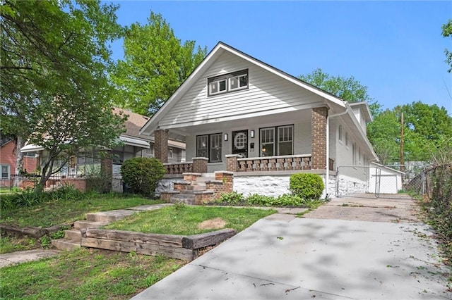 view of front of house with brick siding, a gate, fence, and a porch