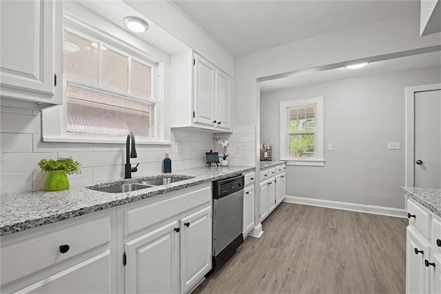 kitchen with light wood-style floors, white cabinets, tasteful backsplash, a sink, and dishwasher