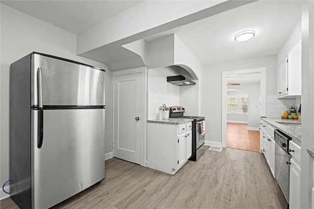 kitchen featuring light wood-style floors, decorative backsplash, white cabinets, and stainless steel appliances