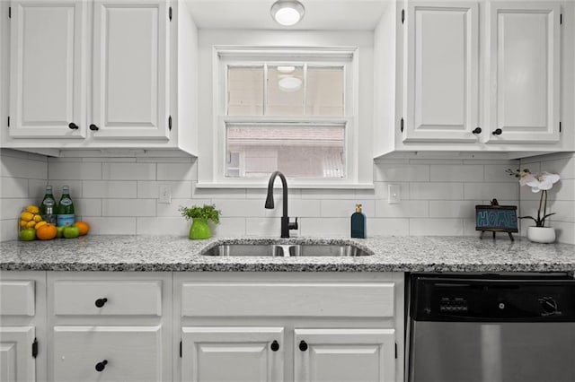 kitchen featuring a sink, white cabinets, stainless steel dishwasher, and backsplash