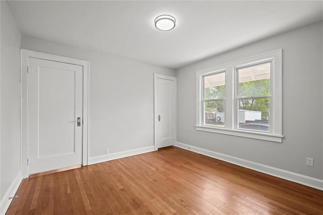 unfurnished room with baseboards and wood finished floors