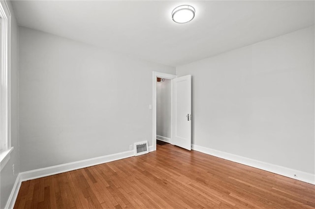 unfurnished room with light wood-type flooring, baseboards, and visible vents