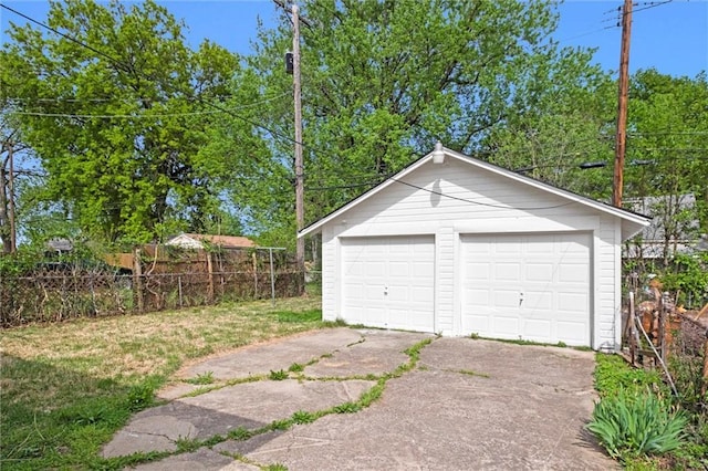 detached garage featuring fence