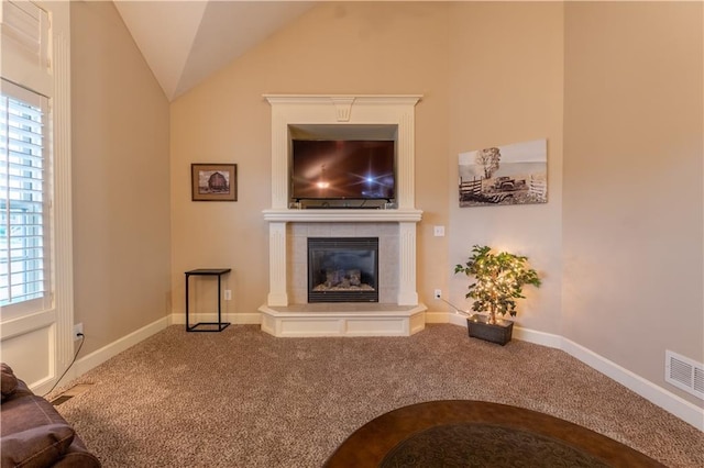 living area with visible vents, carpet flooring, plenty of natural light, and a tiled fireplace