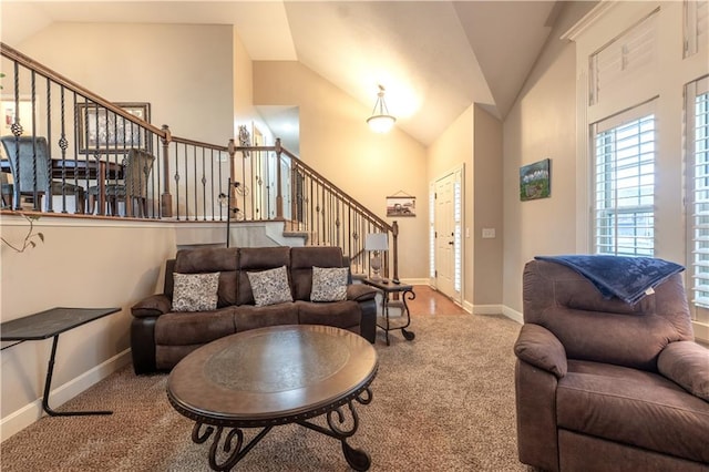 living room featuring carpet flooring, baseboards, vaulted ceiling, and stairway