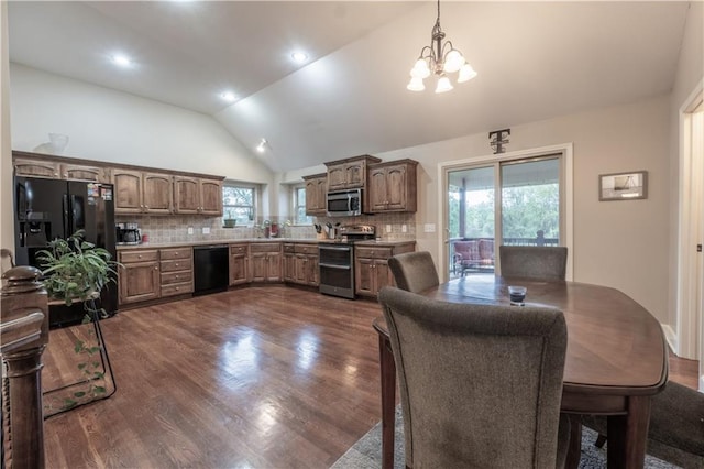 dining space with vaulted ceiling, dark wood-type flooring, and a chandelier