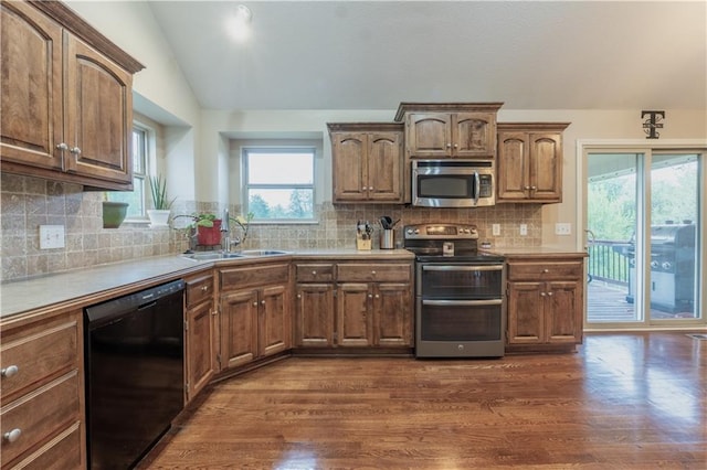 kitchen with stainless steel appliances, vaulted ceiling, dark wood-style floors, and a sink