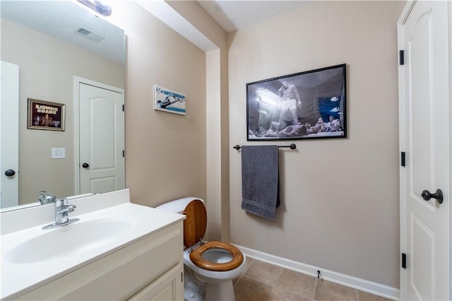 bathroom with toilet, baseboards, visible vents, and vanity