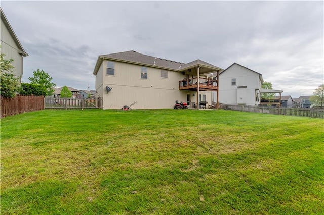 back of house with a lawn and fence