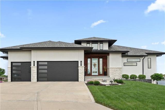 prairie-style house featuring stone siding, a garage, stucco siding, concrete driveway, and a front lawn