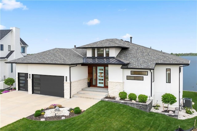 view of front of property featuring a garage, a standing seam roof, driveway, and a front lawn