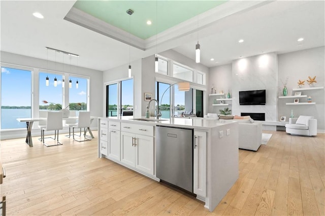 kitchen with a sink, light wood-style floors, healthy amount of natural light, an island with sink, and recessed lighting