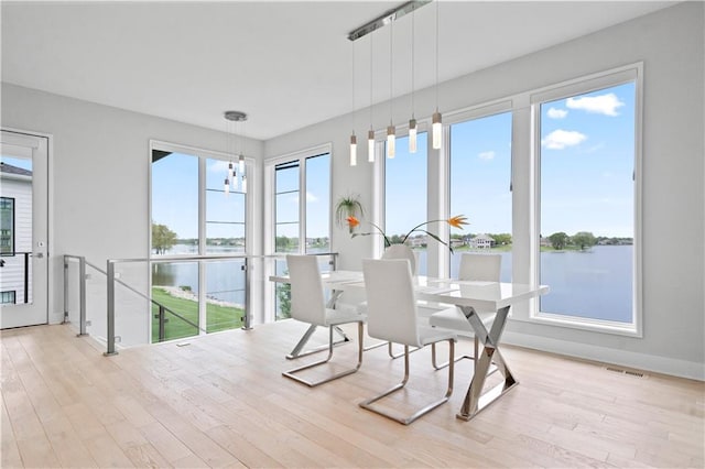 sunroom featuring a water view