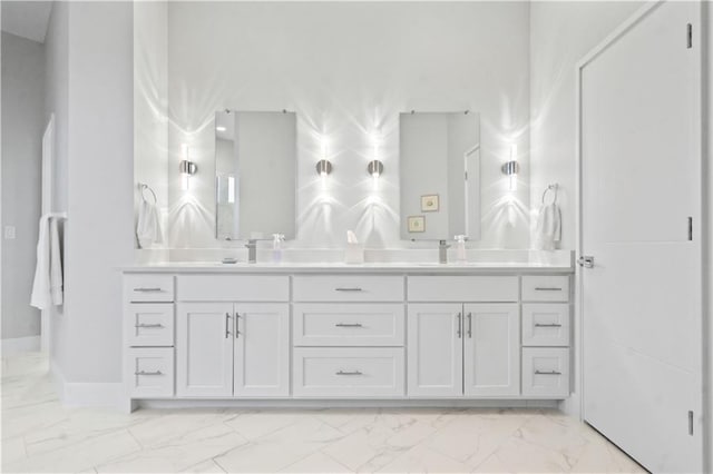 bathroom featuring marble finish floors, double vanity, and baseboards