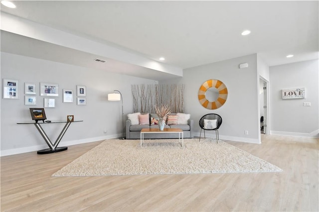 living area featuring wood finished floors, baseboards, and recessed lighting
