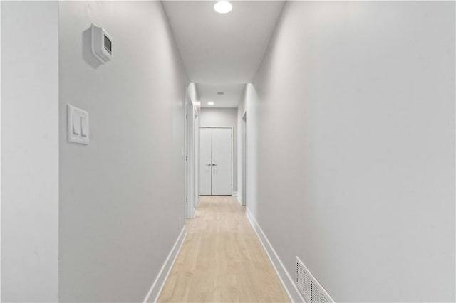 hallway featuring light wood-type flooring, recessed lighting, and baseboards