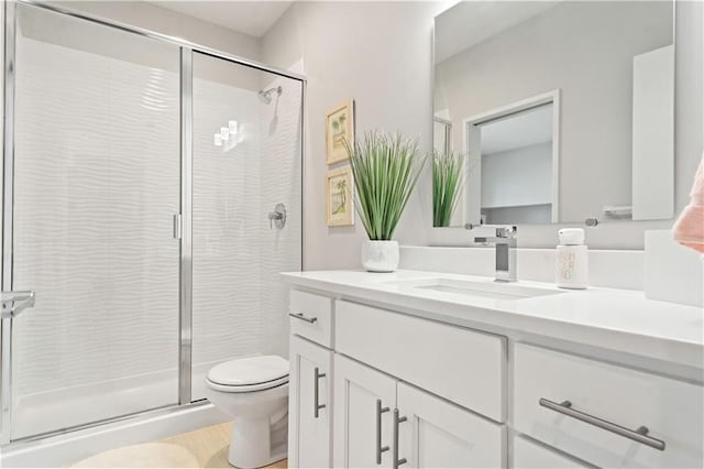 full bath featuring toilet, a stall shower, and vanity