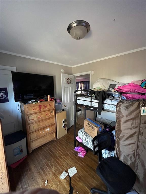 1114 Dakota St, Leavenworth, KS 66048 - bedroom with crown molding and dark wood-style floors