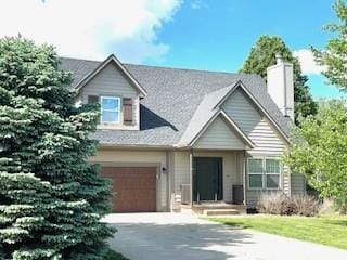 view of front facade featuring a chimney and concrete driveway