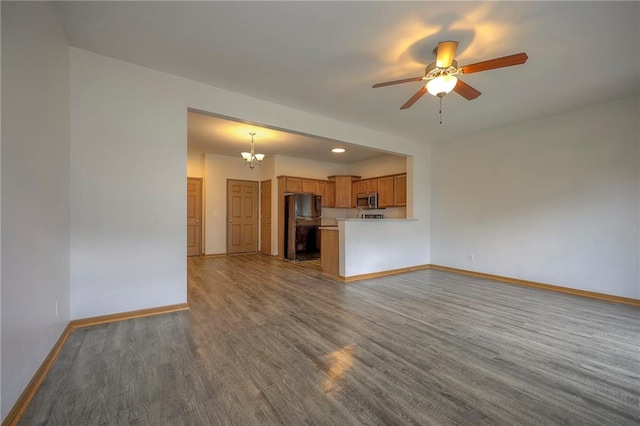 unfurnished living room with recessed lighting, baseboards, wood finished floors, and ceiling fan with notable chandelier