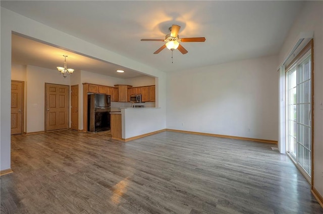 unfurnished living room featuring baseboards, ceiling fan with notable chandelier, recessed lighting, and wood finished floors
