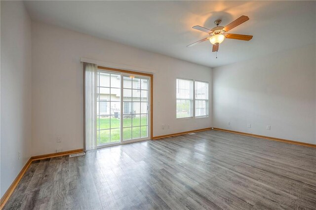 spare room featuring baseboards, a ceiling fan, and wood finished floors