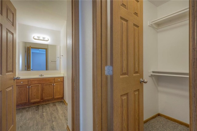 bathroom with vanity, baseboards, and wood finished floors