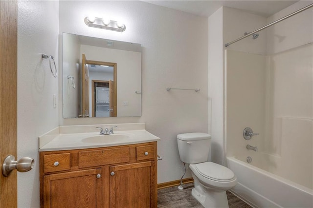 full bathroom with vanity, wood finished floors, toilet, baseboards, and shower / bath combination
