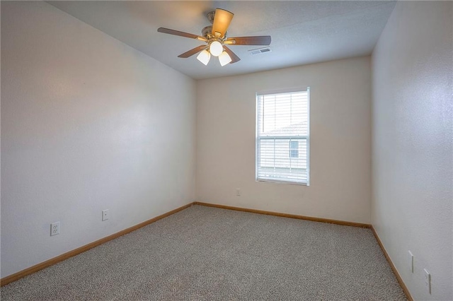 empty room featuring baseboards, light carpet, a ceiling fan, and visible vents