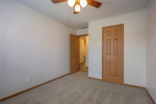 unfurnished bedroom featuring baseboards, carpet flooring, a ceiling fan, and visible vents