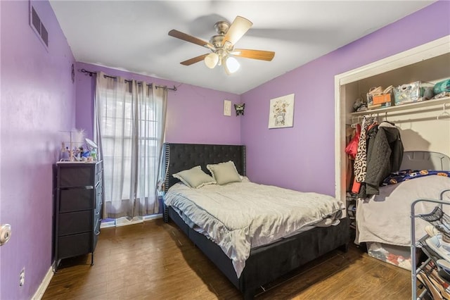 bedroom featuring visible vents, a closet, wood finished floors, baseboards, and a ceiling fan