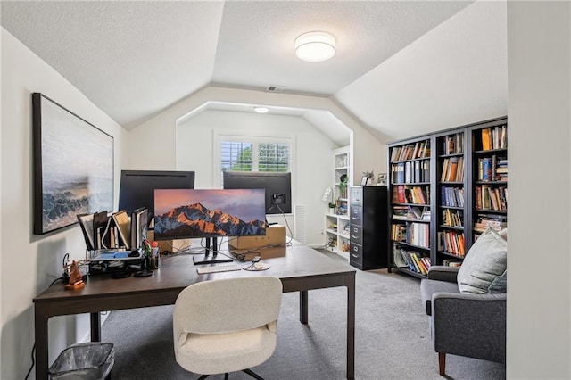 carpeted office space with visible vents, a textured ceiling, and vaulted ceiling