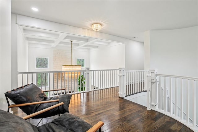 living area featuring beamed ceiling, recessed lighting, an upstairs landing, coffered ceiling, and wood finished floors