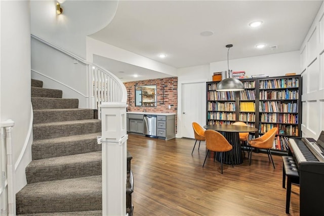 interior space with recessed lighting, stairs, brick wall, and dark wood-type flooring