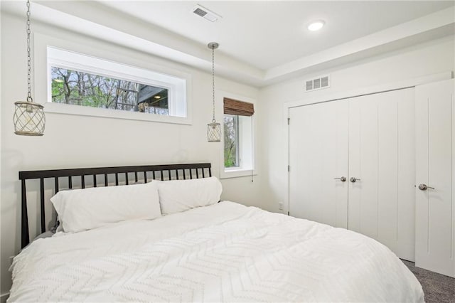 bedroom with visible vents, a closet, and multiple windows