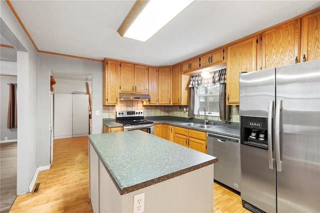 kitchen featuring a sink, stainless steel appliances, under cabinet range hood, light wood-type flooring, and visible vents
