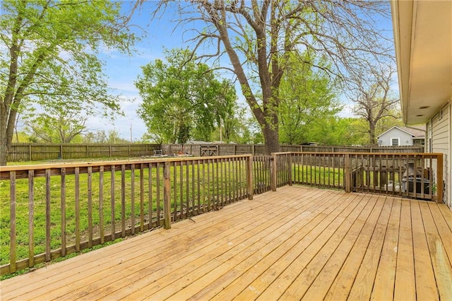 wooden deck featuring a fenced backyard and a lawn