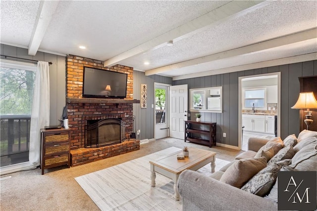 1708 NW Ashton Dr, Blue Springs, MO 64015 - carpeted living room featuring a brick fireplace, beamed ceiling, recessed lighting, a textured ceiling, and a sink