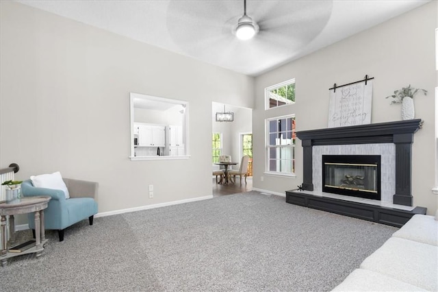 709 SW Graystone Dr, Grain Valley, MO 64029 - living room with a ceiling fan, carpet floors, and a glass covered fireplace