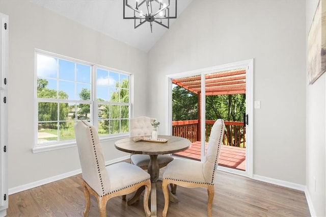 709 SW Graystone Dr, Grain Valley, MO 64029 - dining space with high vaulted ceiling, a chandelier, and wood finished floors