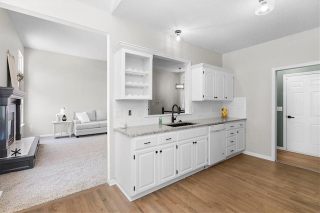 709 SW Graystone Dr, Grain Valley, MO 64029 - kitchen featuring white dishwasher, white cabinets, light wood-style flooring, decorative backsplash, and light stone countertops