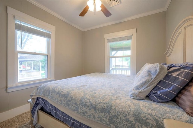 bedroom with crown molding, baseboards, a ceiling fan, and visible vents